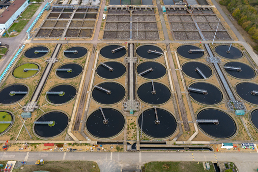 Aerial view of the water treatment plant featuring circular sedimentation tanks and rectangular filtration basins in an industrial facility in Broughton England United Kingdom. Aerial view of the water treatment plant featuring circular sedimentation tanks and rectangular filtration basins in an industrial facility in Broughton England United Kingdom.