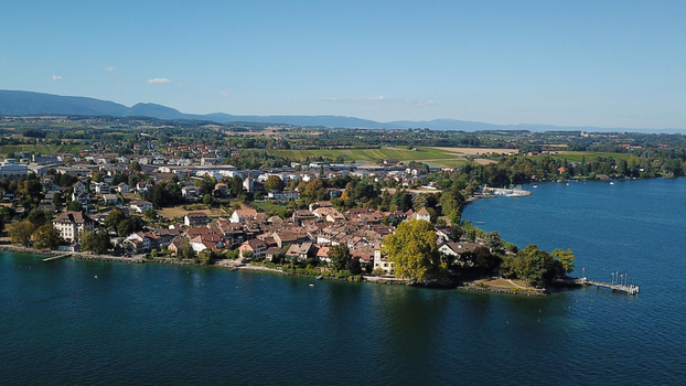 Aerial view of the historic lakeside town on the shores of Lake Geneva with red roofed houses and lush greenery in Saint Prex Vaud Switzerland.