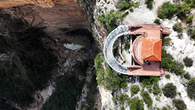 Aerial view of El Vergel canyon with its dramatic rock walls a small pool of water at the base and the observation deck with a red tiled roof in Torotoro Potosi Department Bolivia. Aerial view of El Vergel canyon with its dramatic rock walls a small pool of water at the base and the observation deck with a red tiled roof in Torotoro Potosi Department Bolivia.