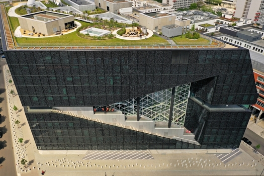 Aerial view of the Axel Springer Neubau featuring its modern dark glass facade unique diagonal atrium and lush green roof terrace in Berlin Berlin Germany. Aerial view of the Axel Springer Neubau featuring its modern dark glass facade unique diagonal atrium and lush green roof terrace in Berlin Berlin Germany.