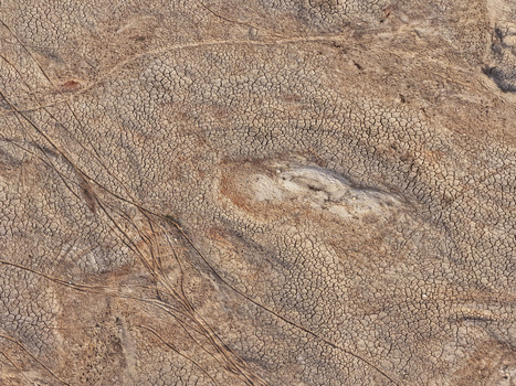Aerial view of the cracked parched earth of the Jadukata River bed with visible tire tracks and dry soil patterns in Sunamganj Sylhet Division Bangladesh. Aerial view of the cracked parched earth of the Jadukata River bed with visible tire tracks and dry soil patterns in Sunamganj Sylhet Division Bangladesh.