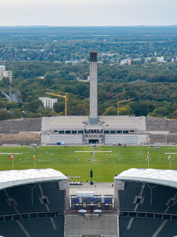 Berlin Germany 26 September 2026 Aerial view of Olympiastadion Berlin with its iconic bell tower expansive green field and surrounding forest landscape.