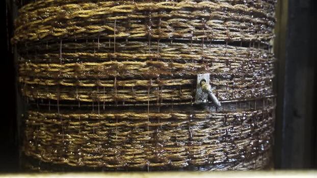 View of traditional olive oil press with oil dripping from mats Greece.