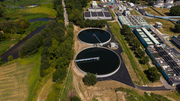 Aerial view of a wastewater treatment plant featuring large circular sedimentation tanks industrial infrastructure and surrounding green landscape in Milan Lombardy Italy. Aerial view of a wastewater treatment plant featuring large circular sedimentation tanks industrial infrastructure and surrounding green landscape in Milan Lombardy Italy.