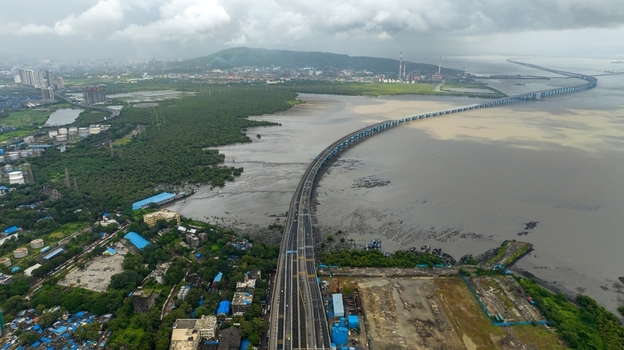 Aerial view of the Atal Bihari Vajpayee Sewri Nhava Sheva Atal Setu bridge stretching across the sea surrounded by lush mangroves and urban infrastructure in Mumbai Maharashtra India. Aerial view of the Atal Bihari Vajpayee Sewri Nhava Sheva Atal Setu bridge stretching across the sea surrounded by lush mangroves and urban infrastructure in Mumbai Maharashtra India.