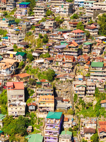 Aerial view of densely packed colorful houses and residential buildings on the steep slopes of Quirino Hill Baguio Cordillera Administrative Region Philippines.
