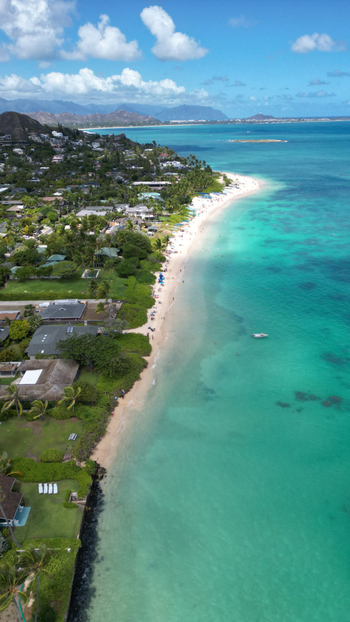 Aerial view of the powdery white sands meeting the turquoise waters at Lanikai Beach a tropical dreamscape under a sky of endless blue Kailua Hawaii United States. Aerial view of the powdery white sands meeting the turquoise waters at Lanikai Beach a tropical dreamscape under a sky of endless blue Kailua Hawaii United States.