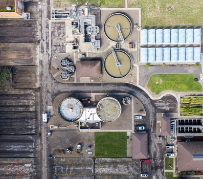 Aerial view of a wastewater treatment plant with circular clarifiers aeration tanks and industrial buildings Woodburn Oregon United States. Aerial view of a wastewater treatment plant with circular clarifiers aeration tanks and industrial buildings Woodburn Oregon United States.