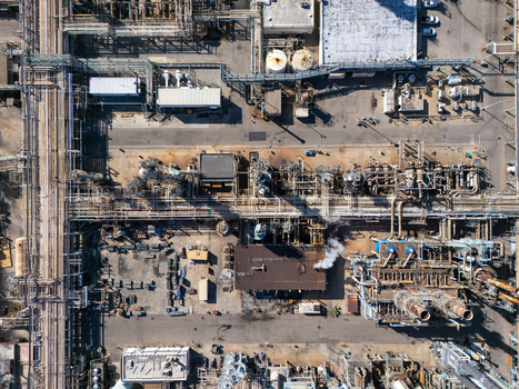 Aerial view of an industrial oil refinery complex with intricate piping storage tanks and processing units in Carson California United States.