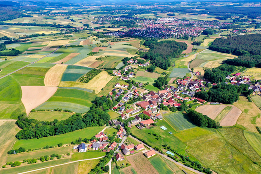 Aerial view of the rural landscape and village houses surrounded by vibrant agricultural fields and dense forests in Neunkirchen am Brand Bavaria Germany. Aerial view of the rural landscape and village houses surrounded by vibrant agricultural fields and dense forests in Neunkirchen am Brand Bavaria Germany.