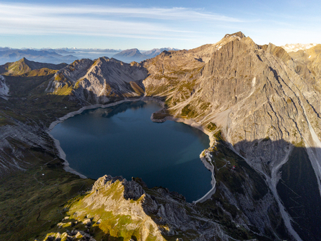 Aerial view of Lunersee surrounded by rugged alpine peaks steep rocky slopes and mountain ridges in Vandans Vorarlberg Austria. Aerial view of Lunersee surrounded by rugged alpine peaks steep rocky slopes and mountain ridges in Vandans Vorarlberg Austria.