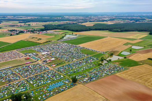 Herzogenaurach Germany 25 July 2025 Aerial view of the Open Beatz Festival campsite with thousands of tents spread across green fields surrounded by forests and rural landscape. Herzogenaurach Germany 25 July 2025 Aerial view of the Open Beatz Festival campsite with thousands of tents spread across green fields surrounded by forests and rural landscape.