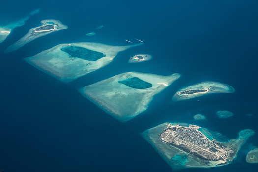 Aerial view of the islands scattered like emerald jewels amidst the sapphire sea a tropical paradise unfolds from above Flight from Male to Hanimaadhoo island Maldives.