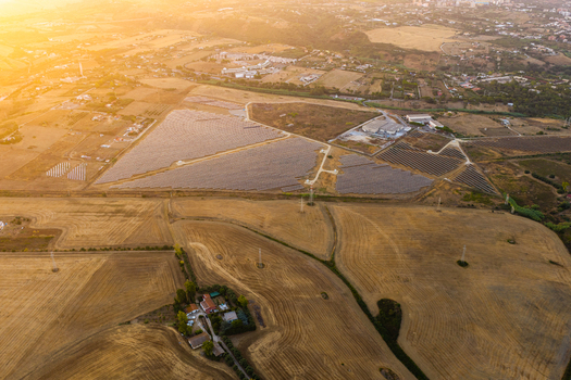 Aerial view of a large solar farm with rows of photovoltaic panels set in dry agricultural fields under the warm glow of sunset Civitavecchia Lazio Italy. Aerial view of a large solar farm with rows of photovoltaic panels set in dry agricultural fields under the warm glow of sunset Civitavecchia Lazio Italy.