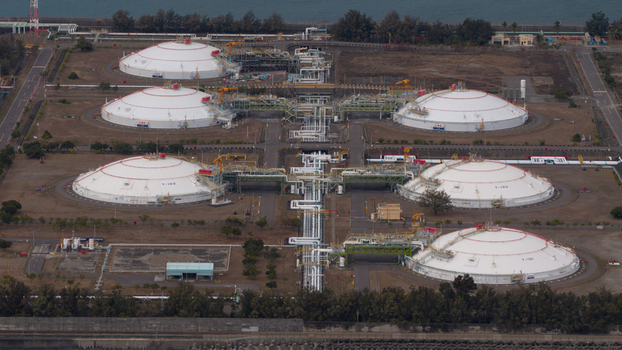 Aerial view of large white LNG storage tanks and industrial piping systems at a coastal energy facility in Xingang Village Kaohsiung City Taiwan.