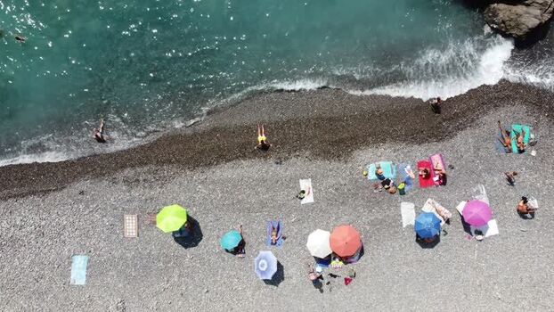 Aerial view of people sunbathing on the beach in Imperia Italy. Aerial view of people sunbathing on the beach in Imperia Italy.