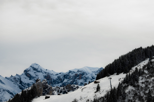View of snow blanketed mountains rise majestically against a pale sky a silent symphony of icy peaks and shadowed evergreens Murren Switzerland. View of snow blanketed mountains rise majestically against a pale sky a silent symphony of icy peaks and shadowed evergreens Murren Switzerland.