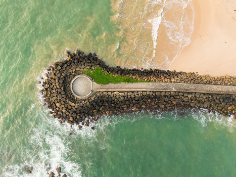 Aerial view of the View Point Mahamodara fishing spot breakwater with turquoise waves crashing against dark rocks and a sandy beach in Galle Sri Lanka. Aerial view of the View Point Mahamodara fishing spot breakwater with turquoise waves crashing against dark rocks and a sandy beach in Galle Sri Lanka.