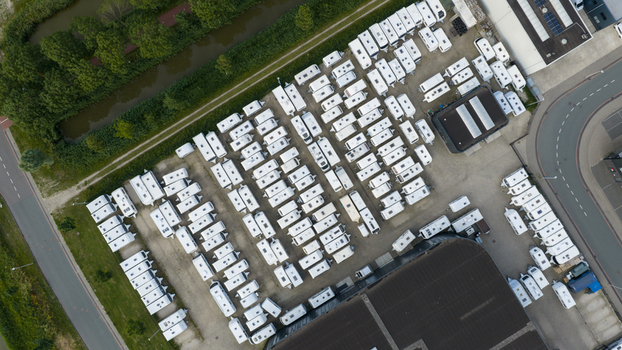Purmerend North Holland Netherlands 15 June 2026 Aerial view of a storage lot filled with white caravans and trailers parked in neat rows next to a warehouse and canal. Purmerend North Holland Netherlands 15 June 2026 Aerial view of a storage lot filled with white caravans and trailers parked in neat rows next to a warehouse and canal.