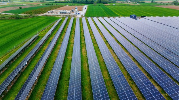 Aerial view of rows of solar panels in a large solar farm surrounded by green agricultural fields and rural landscape Sabac Vojvodina Serbia.