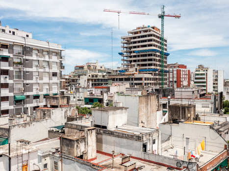 Buenos Aires Argentina 11 July 2022 Aerial view of the dense urban landscape featuring residential apartment buildings rooftops and a large construction site with a crane.