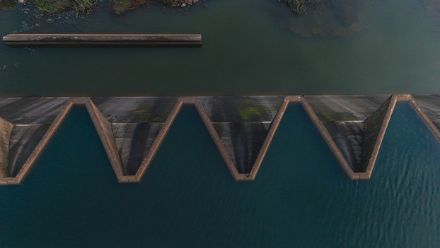 Aerial view of the geometric zigzag pattern of a dam labyrinth spillway with dark water Mooi River KwaZulu Natal South Africa. Aerial view of the geometric zigzag pattern of a dam labyrinth spillway with dark water Mooi River KwaZulu Natal South Africa.