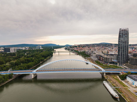 Aerial view of the Apollo Bridge over the Danube river with the city skyline and Eurovea Tower under a cloudy sky in Bratislava Bratislava Region Slovakia. Aerial view of the Apollo Bridge over the Danube river with the city skyline and Eurovea Tower under a cloudy sky in Bratislava Bratislava Region Slovakia.