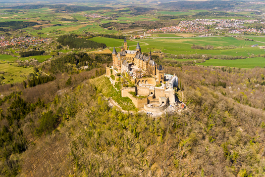 Hechingen Germany 27 September 2026 Aerial view of Hohenzollern Castle perched on a mountain peak surrounded by dense forests and rolling green hills in the Swabian Jura.