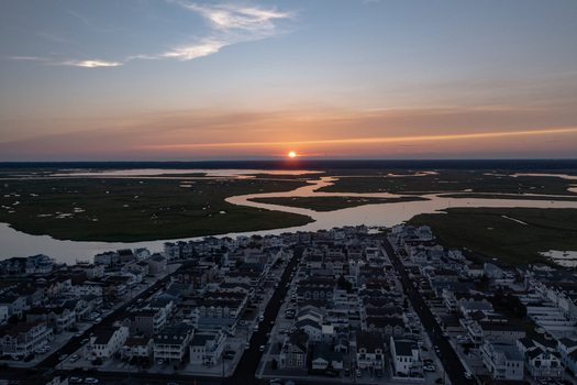 Aerial view of residential neighborhoods and winding marshland waterways at sunset in Sea Isle City New Jersey United States.