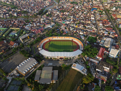 Aerial view of Segiri Stadium surrounded by dense urban housing lush green trees and local infrastructure in Samarinda East Kalimantan Indonesia. Aerial view of Segiri Stadium surrounded by dense urban housing lush green trees and local infrastructure in Samarinda East Kalimantan Indonesia.