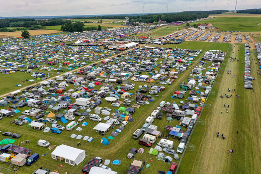 Aerial view of the Open Beatz Festival campsite with numerous tents and vehicles parked in green fields under a cloudy sky in Herzogenaurach Bayern Germany. Aerial view of the Open Beatz Festival campsite with numerous tents and vehicles parked in green fields under a cloudy sky in Herzogenaurach Bayern Germany.