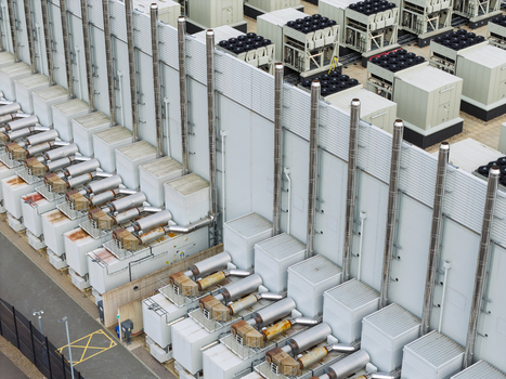 Aerial view of a data center rooftop featuring rows of industrial cooling units ventilation pipes and HVAC systems United Kingdom.