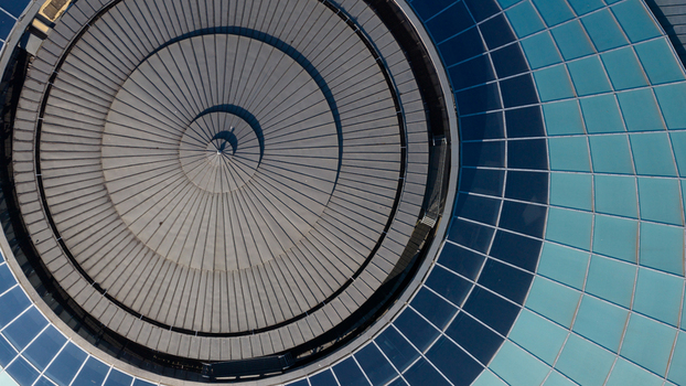 Aerial view of the circular roof of the Wellcome Genome Campus featuring modern glass and metal panels in Hinxton England United Kingdom. Aerial view of the circular roof of the Wellcome Genome Campus featuring modern glass and metal panels in Hinxton England United Kingdom.