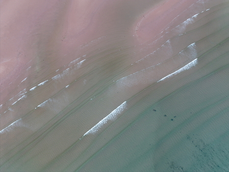 Aerial view of the pink sand beach and gentle turquoise waves at Gruinard Bay in Gruinard Scotland United Kingdom. Aerial view of the pink sand beach and gentle turquoise waves at Gruinard Bay in Gruinard Scotland United Kingdom.