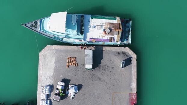 Aerial view of a boat docked at a pier with cargo Maldives.