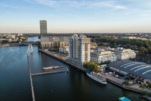 Aerial view of the Molecule Man sculpture standing in the Spree river near the Treptowers office complex in Berlin Berlin Germany. Aerial view of the Molecule Man sculpture standing in the Spree river near the Treptowers office complex in Berlin Berlin Germany.