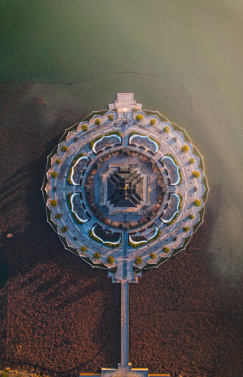 Aerial view of the circular lotus shaped architecture of Chongyuan Temple surrounded by calm water and stone walkways in Suzhou Jiang Su Sheng China. Aerial view of the circular lotus shaped architecture of Chongyuan Temple surrounded by calm water and stone walkways in Suzhou Jiang Su Sheng China.