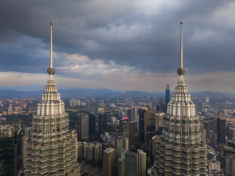 Kuala Lumpur Malaysia 11 March 2026 Aerial view of the Petronas Twin Towers spires overlooking the city skyline under a dramatic cloudy sky.