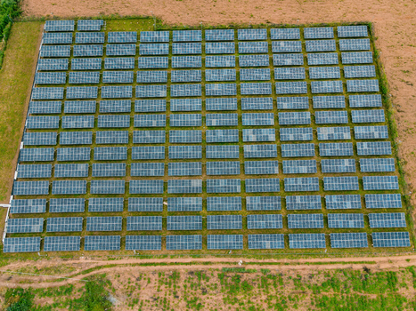 Aerial view of a large solar farm with rows of photovoltaic panels installed in a rural landscape in Ogun State Nigeria.