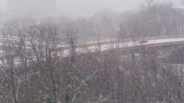 View of heavy snowfall over a highway bridge and bare trees United States. View of heavy snowfall over a highway bridge and bare trees United States.