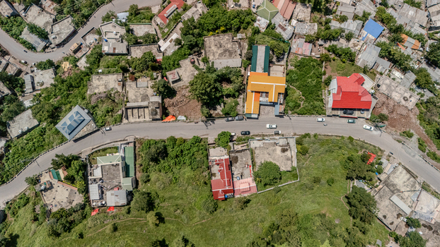 Aerial view of houses with colorful roofs along a winding road in the hilly landscape of Muzaffarabad Azad Kashmir Pakistan. Aerial view of houses with colorful roofs along a winding road in the hilly landscape of Muzaffarabad Azad Kashmir Pakistan.