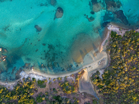 Aerial view of the turquoise waters and sandy coastline surrounded by lush Mediterranean vegetation and rocky outcrops in Marinella Sardegna Italy. Aerial view of the turquoise waters and sandy coastline surrounded by lush Mediterranean vegetation and rocky outcrops in Marinella Sardegna Italy.