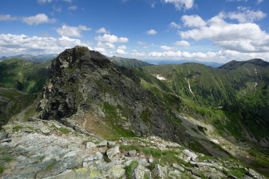 View of Tri kopy in Western Tatras with rocky peaks green mountain ridges and hikers on a trail under a blue sky in Ziar Zilina Region Slovakia. View of Tri kopy in Western Tatras with rocky peaks green mountain ridges and hikers on a trail under a blue sky in Ziar Zilina Region Slovakia.