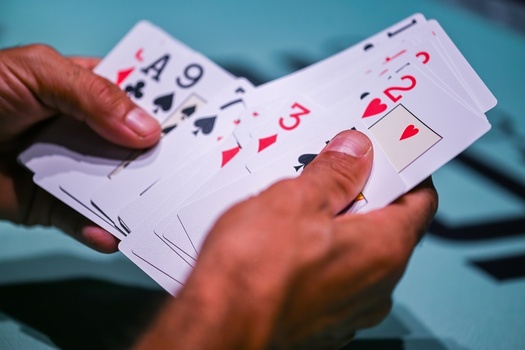 View of a person holding a fan of playing cards during a game in Estoril Lisboa Portugal. View of a person holding a fan of playing cards during a game in Estoril Lisboa Portugal.