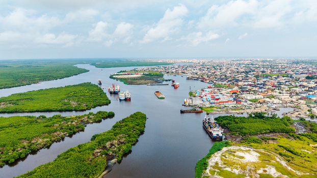 Aerial view of Satellite Town in Lagos showing the river cargo ships industrial port infrastructure and lush mangrove vegetation in Lagos Lagos Nigeria.
