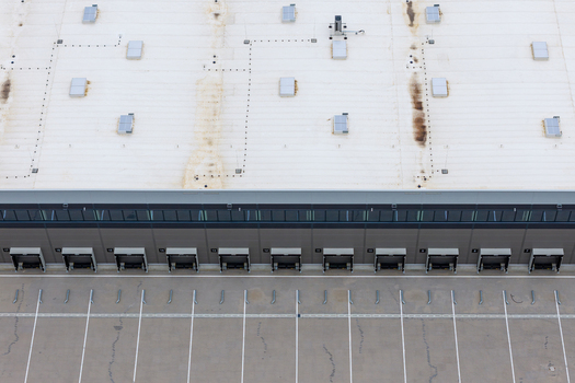 Aerial view of a large distribution hub featuring multiple loading docks and a spacious parking lot with marked bays Poland. Aerial view of a large distribution hub featuring multiple loading docks and a spacious parking lot with marked bays Poland.