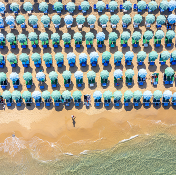 Aerial view of Bat Yam beach with rows of turquoise umbrellas and sunbeds on golden sand by the clear Mediterranean sea Bat Yam Center District Israel. Aerial view of Bat Yam beach with rows of turquoise umbrellas and sunbeds on golden sand by the clear Mediterranean sea Bat Yam Center District Israel.