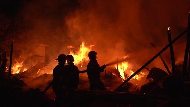 View of firefighters battling a massive blaze at night Bangladesh. View of firefighters battling a massive blaze at night Bangladesh.