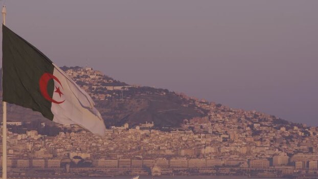 Aerial view of the Algerian flag over the hillside landscape of Algeria.