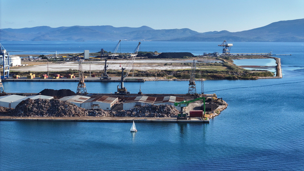 Aerial view of Port of Ploce with industrial cranes shipping containers and a small sailboat on the water under a clear blue sky in Croatia. Aerial view of Port of Ploce with industrial cranes shipping containers and a small sailboat on the water under a clear blue sky in Croatia.